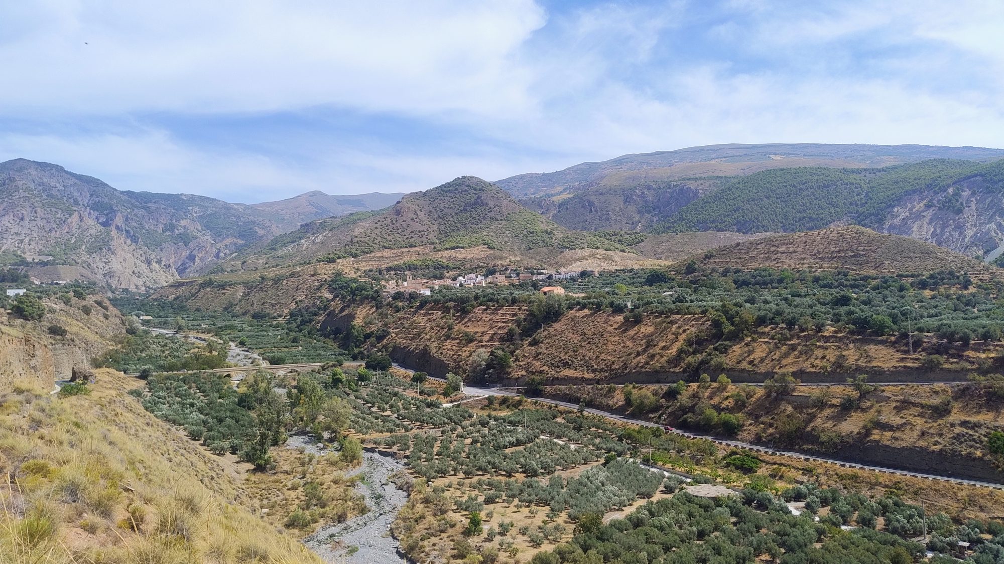 El caserío blanco de Acequias sobre la ladera, con Sierra Nevada al fondo